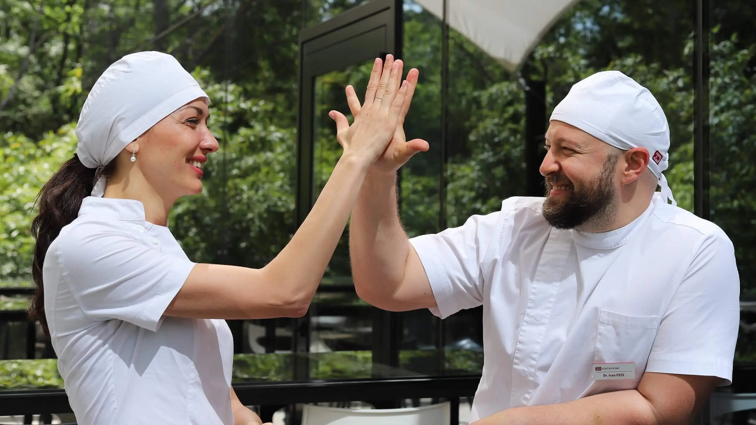 UK dental clinic staff implantology dentists group photo with happy dental patients after full mouth restoration treatment